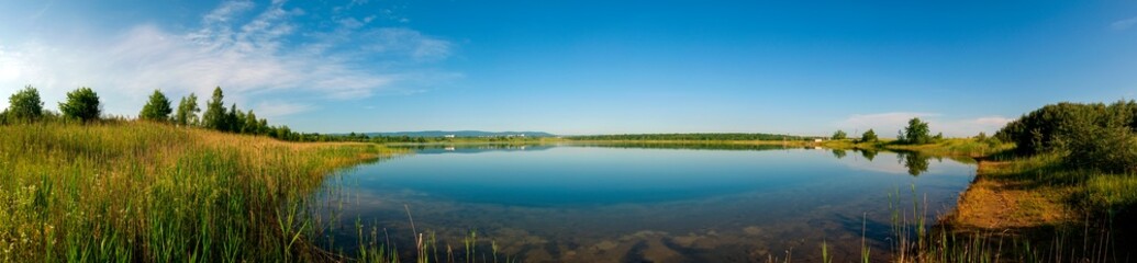 Panoramic view of a calm lake on a sunny summer day