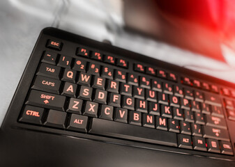 Keyboard close up with red keys and buttons.