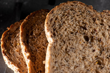 Detailed close up of high fibre low GI seven seeds and grain bread in low key lighting