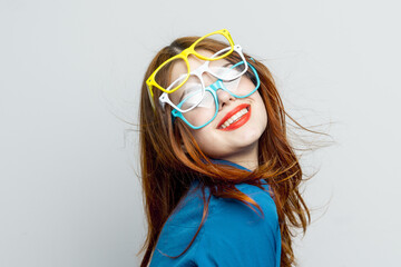 woman with multicolored glasses on her face in blue shirt posing glamor