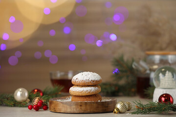 Delicious cookies and Christmas decor on wooden table against blurred festive lights