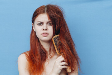 pretty woman combing naughty hair blue background