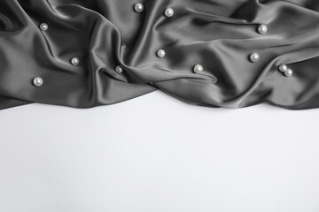 Texture of delicate black silk with pearls on white background