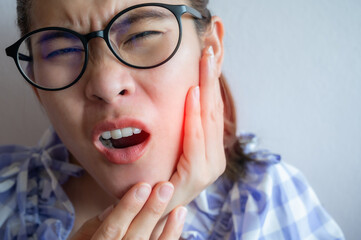 Close up of Asian woman having suffering from toothache. Toothaches can be caused by something happening to your teeth or gums.