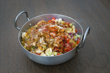 Indian delicious home made chaat of chickpeas, tomatoes, fruits, masalas in aluminium wok