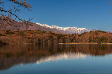Fototapeta na wymiar 青木湖に映る紅葉と雪を被った白馬連山