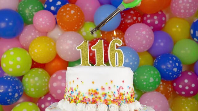 Cake with burning candles number 116. A tasty Birthday Cake on a bright festive background of colorful balloons.