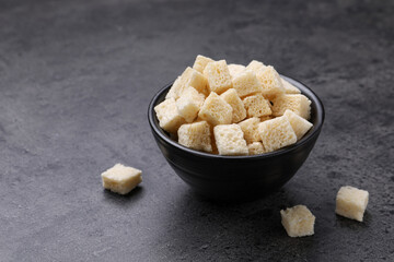 Crispy rusks in bowl on grey table