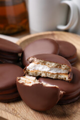 Tasty choco pies on wooden plate, closeup view