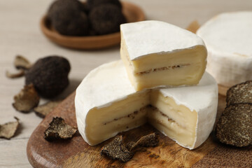 Delicious cheese with fresh truffles on wooden table, closeup