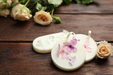 Scented sachets and flowers on wooden table