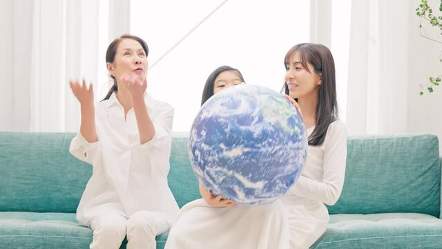 地球の模様のボールを見る三世代家族　環境イメージ　SDGs