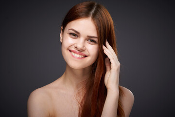 pretty red-haired woman naked shoulders posing dark background