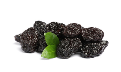 Heap of sweet dried prunes and green leaves on white background
