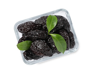 Bowl with sweet dried prunes and green leaves isolated on white, top view