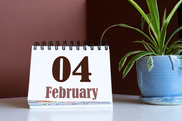 February 4th. Day 4 of February month, calendar on brown workplace background. Winter time