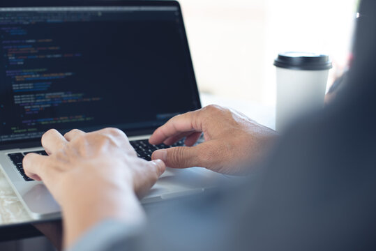 Web or application development, technology concept. Programmer, man software engineer, app developer hands coding HTML, programming Javascript on laptop computer