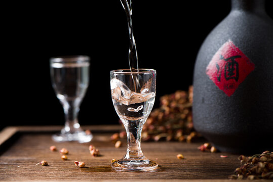 Chinese Liquor Is Pouring Into A Glass From A Bottle On Table