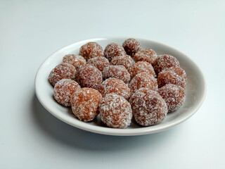 Tamarind candy, placed inside white small plate. Sweet and sour candy made from tamarind paste and coated by sugar.