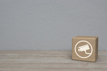 cctv camera flat icon on wood block cube on wooden table over white wall background, Technology...