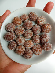 Tamarind candy, placed inside white small plate. Sweet and sour candy made from tamarind paste and coated by sugar.
