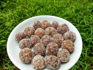 Tamarind candy, placed inside white small plate. Sweet and sour candy made from tamarind paste and coated by sugar.