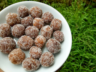 Tamarind candy, placed inside white small plate. Sweet and sour candy made from tamarind paste and coated by sugar.