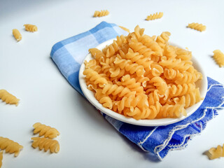 Uncooked fusilli on the white small plate