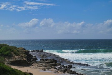 Macn watching waves crach on rocky beach