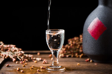 chinese liquor is pouring into a glass from a bottle on table