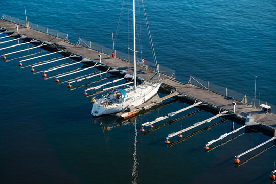 Top View Of Many Floating Piers With Sailboat On Water. Travel And Vacation Concept.