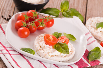 Rice cakes with milk flakes and tomato.