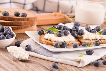 Rye bread with cottage cheese, blueberries and honey.