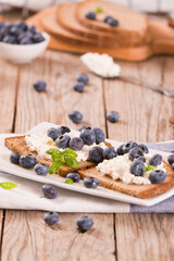 Rye bread with cottage cheese, blueberries and honey.