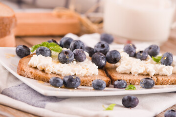 Rye bread with cottage cheese, blueberries and honey.