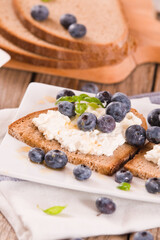 Rye bread with cottage cheese, blueberries and honey.