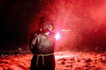 Medieval plague doctor stands in the bloody snowfall. Medieval Europe. Halloween.