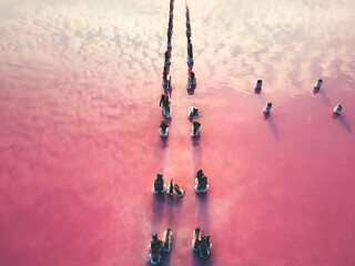 Salt industry on the pink lake. Sky reflected in the water surface. Abstract nature background....
