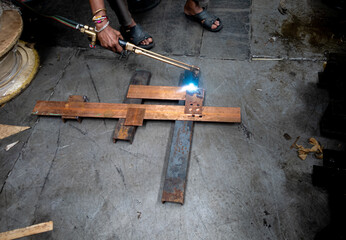 A man joining the copper sheets with the help of gas welding process.