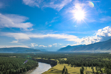 Bright sun, blue sky over the mountain valley and the river. Summer landscape. Good weather.