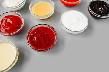 Various sauces on gray, copy space. From above.