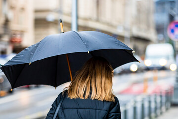 People with umbrella on the street on a rainy day in Bucharest, Romania, 2021