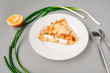 Person eating crepes with filling. Tasty breakfast.