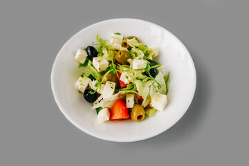 Greek salad on gray background. Front view.