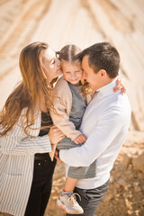 A young family with a daughter among the sand and blue sky 3307.