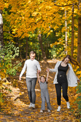 Obraz premium Autumn walk of a young family in the forest 3373.