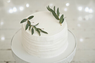 A cake on a high stand and decorations of green twigs 3409.