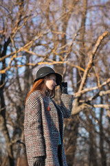 A large portrait of a girl against the background of spring trees still without leaves 3493.