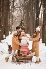 A big family is happy with a Christmas tree and gifts on the background of
