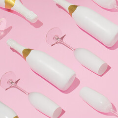Trendy Christmas pattern with bottles and glasses of champagne against pink background. Minimal New Year party concept.